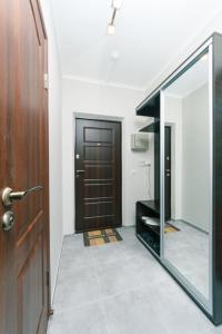 a hallway with a wooden door and a mirror at Уютные апартаменты на Улице Русова 7 метро 15 минут in Kyiv