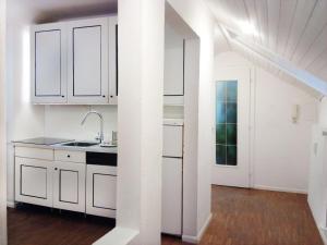 eine weiße Küche mit weißen Schränken und einem Waschbecken in der Unterkunft Ugo Architect's Bright Loft in Bozen