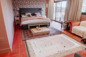 a bedroom with a bed and a tub in the floor at Hotel Boutique Pinar in Cuenca