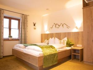 Un pat sau paturi într-o cameră la Ahorn-Appartements - Chiemgau Karte