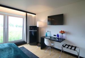 Schlafzimmer mit einem Bett, einem Schreibtisch und einem Fenster in der Unterkunft KF Hotel by WMM Hotels in Kaufbeuren