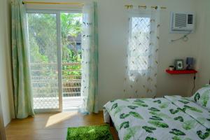 um quarto com uma cama e uma grande janela em MAILZ HAVEN BEAUTIFL 3BR MODERN APRT NEAR SM DOOR-D em Davao