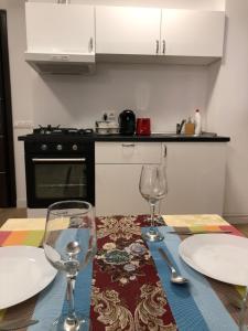 a table with two wine glasses and plates on it at Upground Apartments in Bucharest