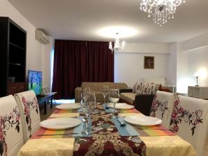 a dining room with a table and chairs and a living room at Upground Apartments in Bucharest
