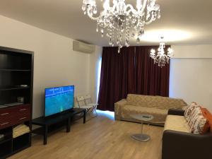 a living room with a couch and a chandelier at Upground Apartments in Bucharest