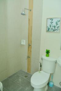 uma casa de banho com um WC branco e um chuveiro em MAILZ HAVEN BEAUTIFL 3BR MODERN APRT NEAR SM DOOR-D em Davao