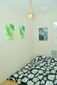 a bed in a room with pictures on the wall at MAILZ HAVEN BEAUTIFL 3BR MODERN APRT NEAR SM DOOR-D in Davao City