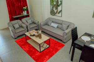 uma sala de estar com dois sofás e um tapete vermelho em MAILZ HAVEN BEAUTIFL 3BR MODERN APRT NEAR SM DOOR-D em Davao