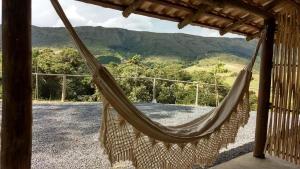 a hammock on a porch with a view of the mountains at Pousada Mirante dos Ipês - Capitólio - MG in Capitólio