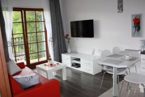 sala de estar con sofá rojo y mesa en Apartament Sofii w Centrum, en Zakopane