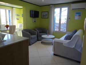 Una sala de estar con dos sillas y una mesa. en Appartement T2 50m² vue mer Presqu'il de Giens. RC, en Hyères