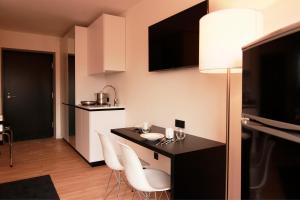 a kitchen with a table and chairs in a room at ME Hotel by WMM Hotels in Meitingen
