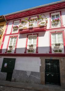 a red and white building with windows and flowerpots at Saioa`s red house in Lekeitio