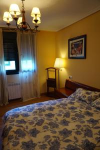 Un dormitorio con una cama y una lámpara y una ventana. en Apartamento rural Felechosa, en Felechosa