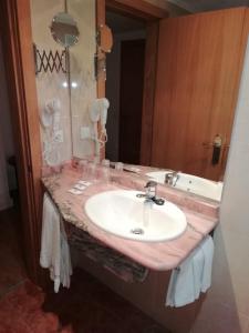 W łazience znajduje się umywalka i lustro. w obiekcie Hotel Brasa w mieście Elvas