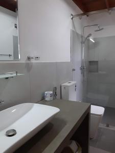La salle de bains est pourvue d'un lavabo, de toilettes et d'une douche. dans l'établissement Blue Sands Beach Resort, à Pasikuda