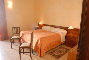 sypialnia z łóżkiem, krzesłem i lustrem w obiekcie Hotel Gresi w Katanii +20 zdjęć