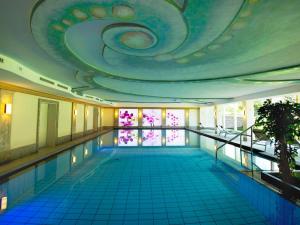 una piscina con un grande soffitto e una piscina di Das Pfandler Hotel a Pertisau