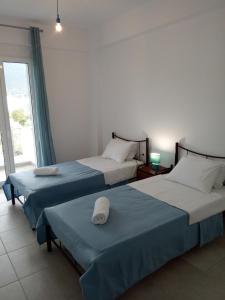 two beds in a room with a window at Almira Ghouse in Almiropotamos