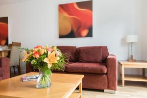 a living room filled with furniture and flowers at PREMIER SUITES Birmingham in Birmingham
