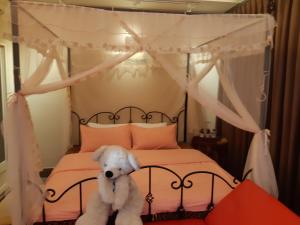 a white teddy bear sitting on a bed at Shuanghu Garden B&B in Shuangxi