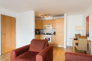a living room with a couch and a kitchen at PREMIER SUITES Birmingham in Birmingham