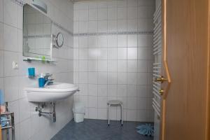 ein weißes Badezimmer mit einem Waschbecken und einem Spiegel in der Unterkunft Ferienhaus Olympia in Lermoos