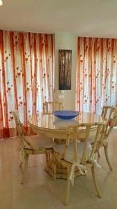 una mesa de comedor con sillas y un tazón azul. en Apartamento El Rincon Benidorm, en Benidorm