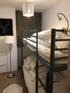 - deux lits superposés dans une chambre avec une lampe dans l'établissement Charmant Appartement Centre Ville Valloire, à Valloire