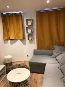 a living room with a couch and a table at Charmant Appartement Centre Ville Valloire in Valloire