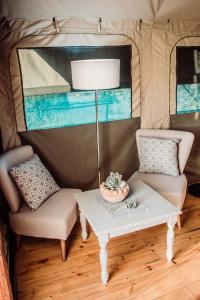 a living room with a table and chairs in a camper at Chandelier Game Lodge in Oudtshoorn