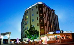 a tall building with a tree in front of it at meryemana hotel in Didim