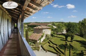 a balcony of a house with a view of a garden at Château de Mayragues in Castelnau-de-Montmiral