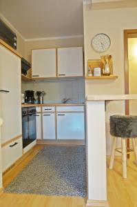 a small kitchen with white cabinets and a table at Appartment Indira in Bad Sobernheim