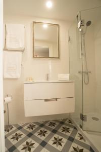 a bathroom with a sink and a mirror and a shower at Mercado dos Poetas – Tourism Apartments in Porto