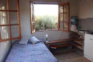 Habitación pequeña con cama y ventana en Cabaña Nachitor, en San Pedro de Atacama