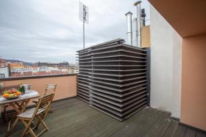 a room with a table and chairs on a balcony at LUXURY CENTRAL DUPLEX WITH TERRACE in Prague