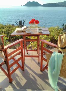 a wooden table with two chairs and a table with books at Enalion House in Agios Ioannis Kaspaka