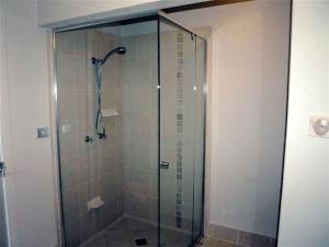 a shower with a glass door in a bathroom at @BLUEYS in Blueys Beach