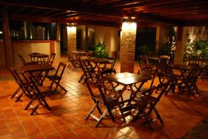 - un ensemble de tables et de chaises en bois dans une chambre dans l'établissement Pousada Vitalis, à Olímpia