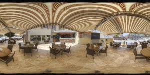 a restaurant with wooden ceilings and tables and chairs at meryemana hotel in Didim