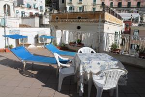 a table and chairs on top of a balcony at Attico del Cavaliere in Atrani