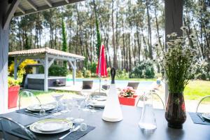 una mesa con platos y copas de vino. en Villa Messanges (piscine & spa) en Messanges