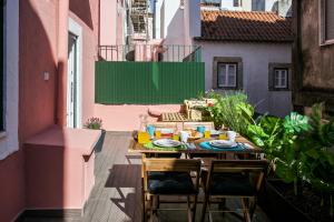 einen Tisch und Stühle auf einer Terrasse auf einem Balkon in der Unterkunft Hip Tailor Made Flat in Bairro Alto in Lissabon