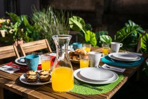 a wooden table with plates of food and orange juice at Hip Tailor Made Flat in Bairro Alto in Lisbon