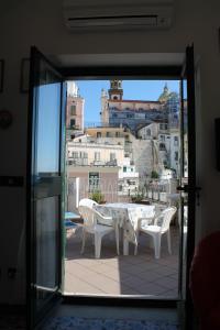 a table and chairs on a balcony with a view at Attico del Cavaliere in Atrani +3 photos