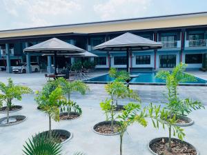 素辇府โรงแรมมาลินี的建筑前方的庭院,有树木和遮阳伞