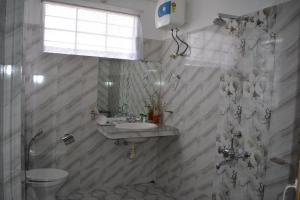 un bagno con lavandino, wc e doccia di Dew Drop In a Shillong