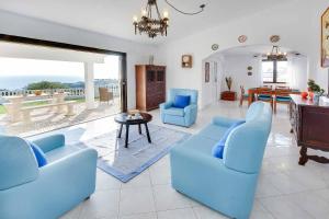 a living room with two blue chairs and a table at Villa Brigida in Albufeira