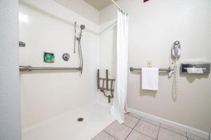 a bathroom with a shower with a phone on the wall at Turlock Inn in Turlock